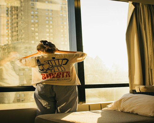 Person stretching gently near a window at home in the morning